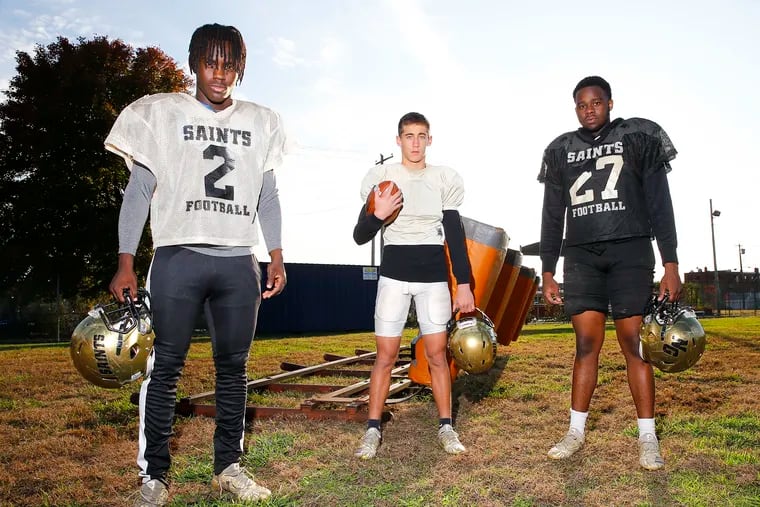 Three Neumann-Goretti seniors -- linebacker Ron Holmes (left), wide receiver Damian Gabriel (center) and defensive lineman/linebacker Roman Brown -- were freshmen when the team was 0-7 and canceled the remainder of season because of a shortage of players.  Now the Saints are 11-0 and angling for a state title.