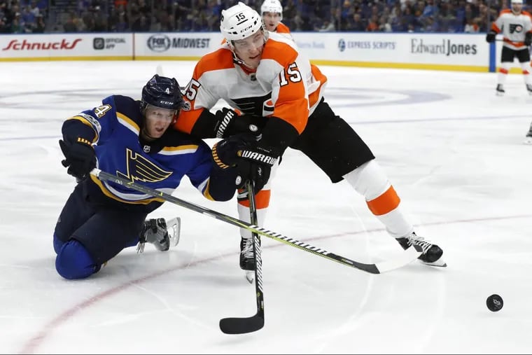 Blues’ Carl Gunnarsson, left and Flyers’ Jori Lehtera chase after a loose puck during the third period of the Flyers’ win on Thursday.