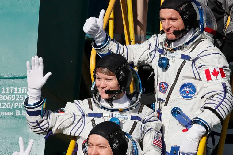 U.S. astronaut Anne McClain, centre, Russian cosmonaut Оleg Kononenko, bottom, and CSA astronaut David Saint Jacques, crew members of the mission to the International Space Station, ISS, wave as they board the rocket prior to the launch of Soyuz-FG rocket at the Russian leased Baikonur cosmodrome, Kazakhstan, Monday, Dec. 3, 2018. (AP Photo/Shamil Zhumatov, Pool)