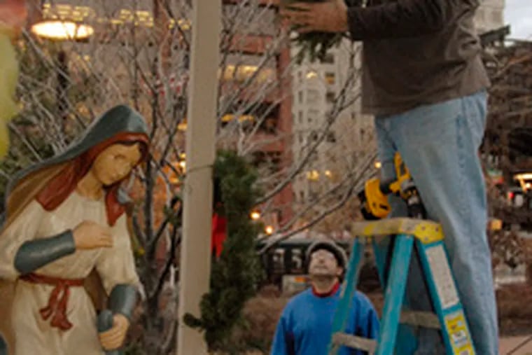 Ancient Order of Hibernians member Tony Nahill works on nativity display that was vandalized. Baby Jesus in photo is a loaner.