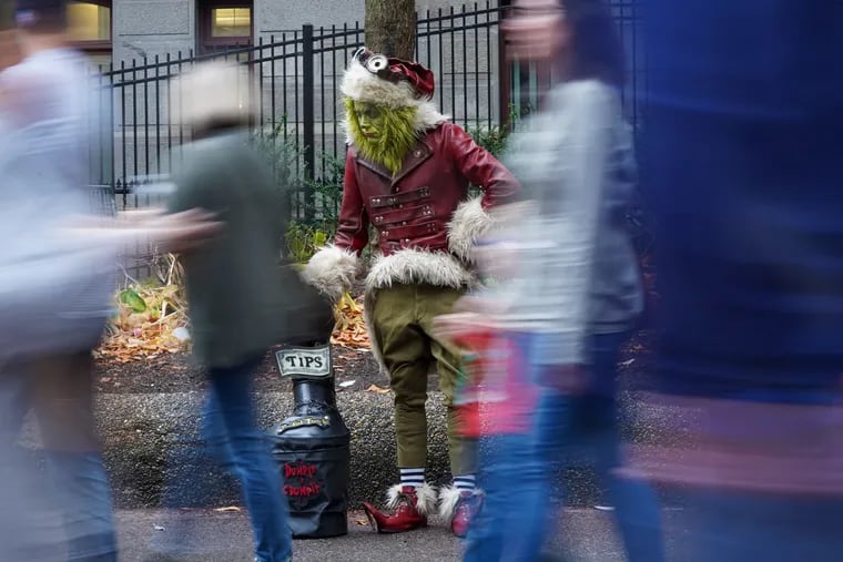 A street performer dressed as the Grinch at Christmas Village at City Hall.