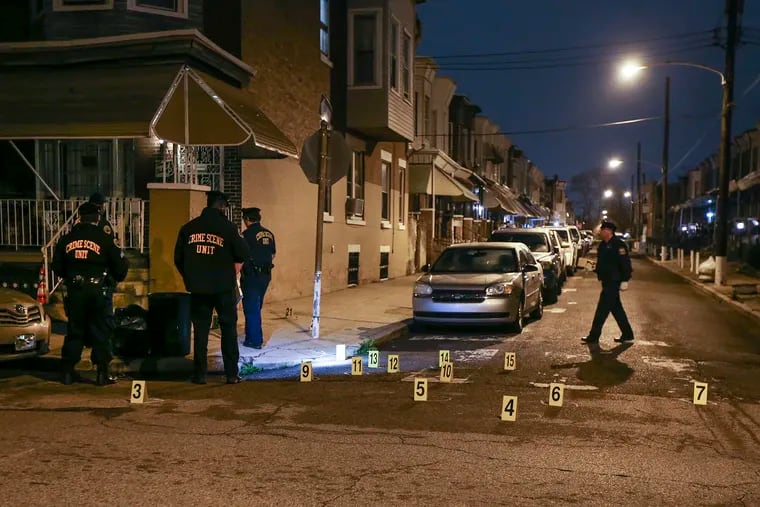 Philadelphia Police Crime Scene Unit officers survey the 2300 block of West Harold Street on Tuesday, March 31, 2020, after five people were shot there Monday night.