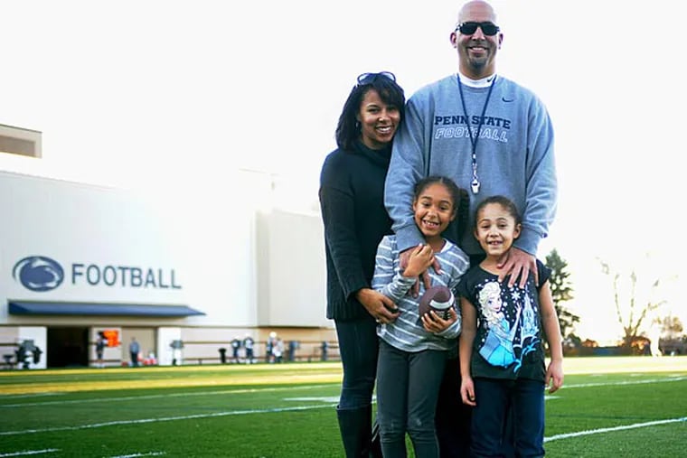 The Franklin family poses before football practice on Tuesday. Since becoming the Head Football Coach at Penn State, James Franklin, his wife Fumi Franklin, and their two daughters Shola and Addy, have been adjusting to living in state college. (Photo by Leah Eder)