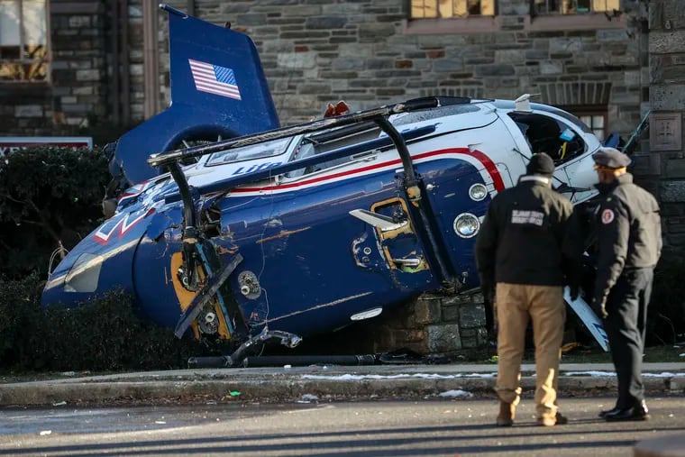 Officials take a look at the scene of a helicopter crash at Burmont Road and Bloomfield Avenue in Drexel Hill on Tuesday. A medical helicopter carrying an infant crashed in the residential neighborhood, leaving the four passengers with non-life threatening injuries, according to local authorities.