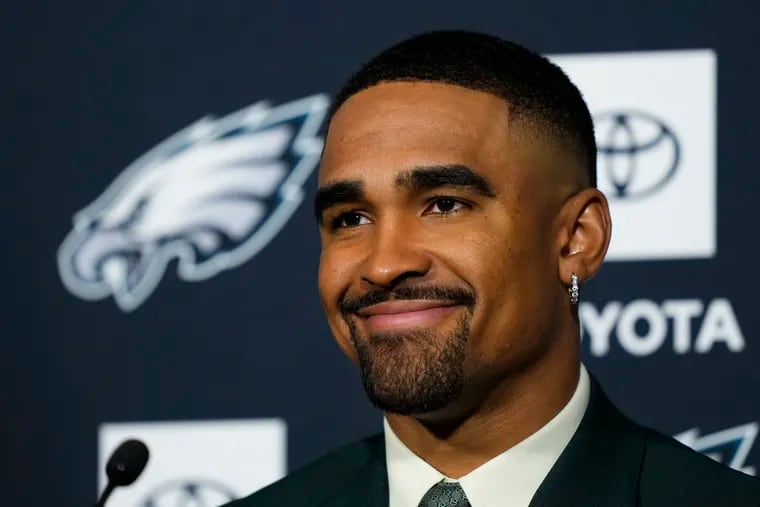 Eagles quarterback Jalen Hurts, shown after signing his new contract, won't let his $255 million extension slow him down.