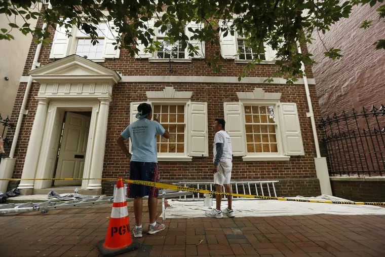 Workers Lewis Brito (left) and Carlos Mayo  prepare to paint the Dilworth House in Washington Square. The home was recently cited for violations by the city’s Licenses and Inspections.