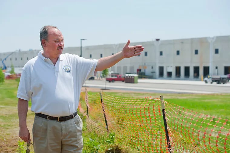 Mayor Craig Wilkie stands outside the massive, still under construction Amazon.com distribution center in Florence Township, NJ.