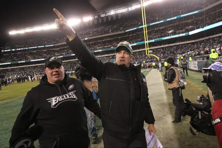 Eagles head coach Doug Pederson (right) signals to the crowd at Lincoln Financial Field after the Eagles beat the Falcons on Saturday.