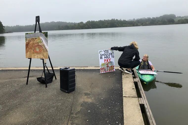 West Whiteland resident Ginny Marcille-Kerslake, (left) with sign protesting the Mariner East pipeline, speaks with fellow protestor Libby Madarasz at Marsh Creek Lake in October. The lake was the site of a spill of pipeline construction fluid.