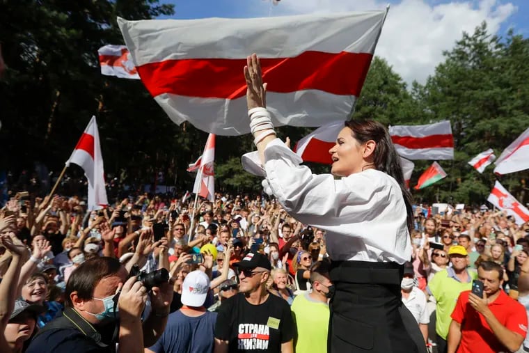 Sviatlana Tikhanovskaya, candidate for the presidential election in Belarus, greets people waving old flags during a campaign rally on Aug. 2.