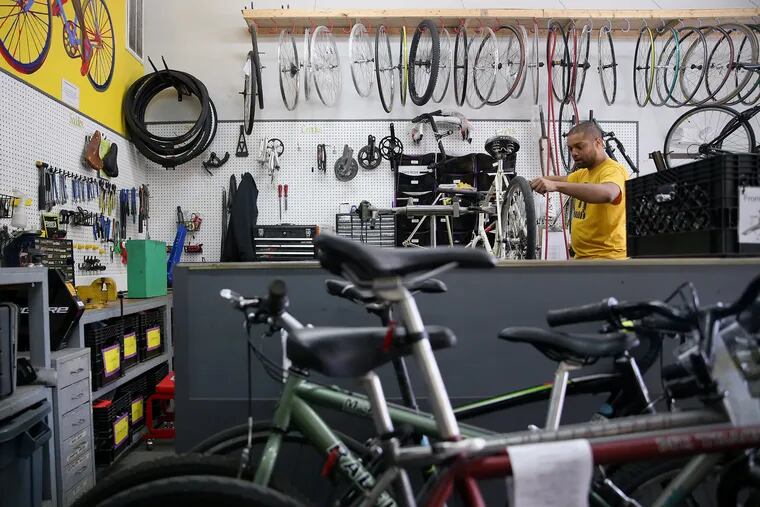 Mechanic Barron Johnston refurbishes a donated bicycle at Neighborhood Bike Works in West Philadelphia. The bike shop is launching a new program to give refurbished bikes to essential workers during the coronavirus pandemic.