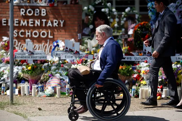 Texas Gov. Greg Abbott passes in front of a memorial outside Robb Elementary School to honor the victims killed in a school shooting in Uvalde, Texas, May 29, 2022.  In the aftermath of the school shooting in Uvalde, Texas, governors around the country vowed to take steps to ensure their students would be kept safe. Months later, as students return to classrooms, money has begun to flow for school security upgrades, training and other new efforts to make classrooms safer.