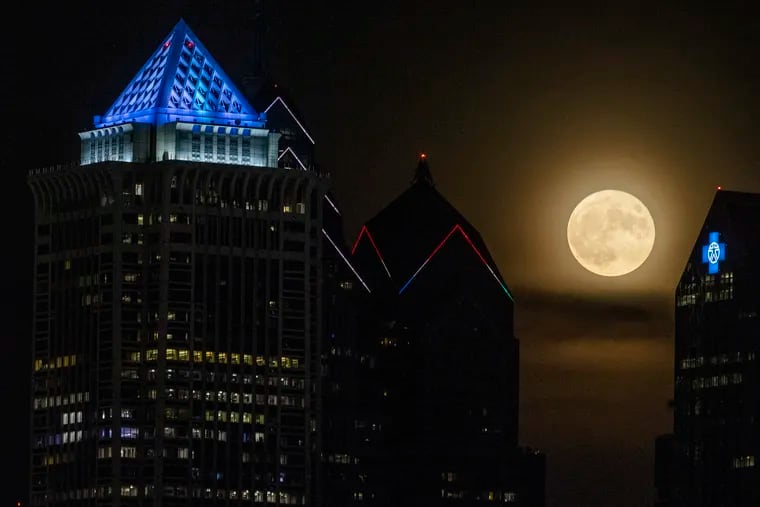 The supermoon rises over the city on July 13, 2022