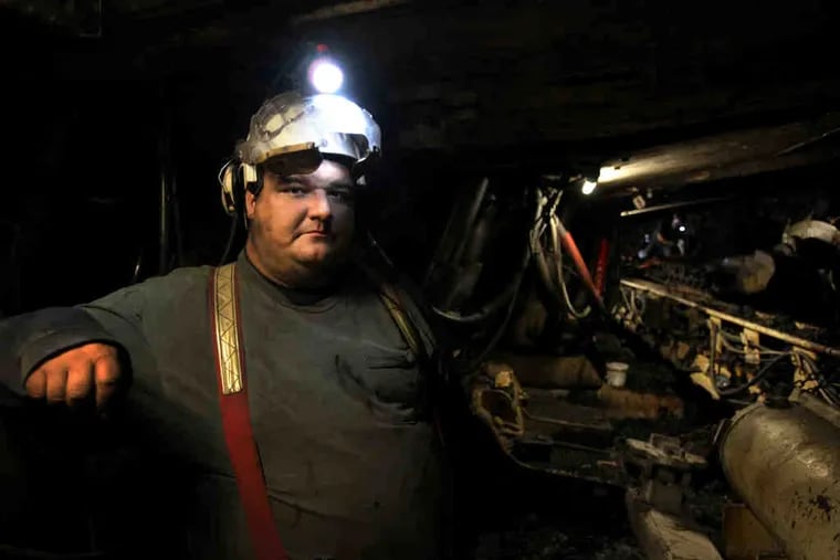 Dwight Harris operates the protective shields on a machine that carves coal from the walls of the Cumberland Mine, where up to 101 million tons of coal lie.