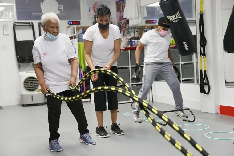 Yvonne Hardin (center) helps her mother, Una Doyley (left), 94, with a ropes exercise during a class for older adults at Fergie's Fit Foundation in Philadelphia's East Germantown section on Saturday, March 6, 2021.