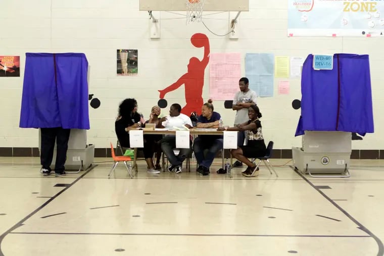 Polling volunteers sit at Thomas G. Morton school on Primary Election Day in Philadelphia on Tuesday, May 19, 2015.