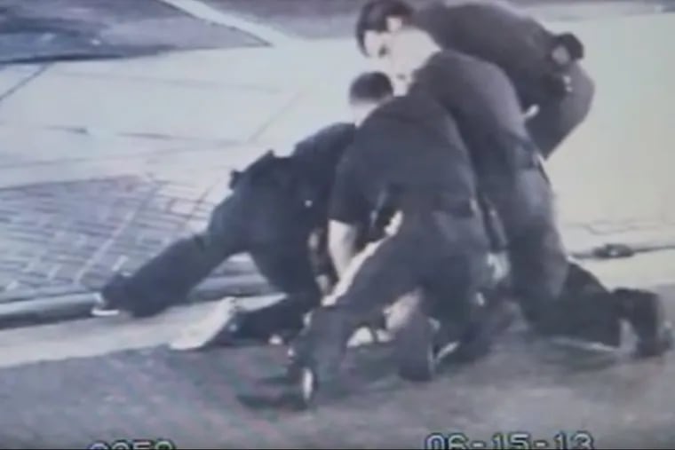 Image from surveillance video showing four Atlantic City police officers in a pile on top of  David Connor Castellani during a 2013 arrest. The city paid Castellani $3 million to settle a federal civil-rights lawsuit that arose from the incident.