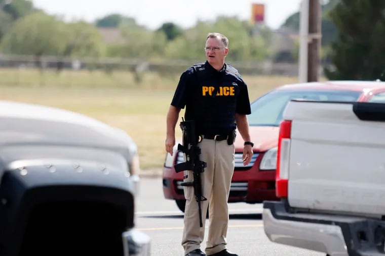 A law enforcement officer stands in the middle of the 5100 block of E. 42nd Street in Odessa, Texas, Saturday, Aug. 31, 2019, following a shooting at random in the area of Odessa and Midland. Several people were dead after a gunman who hijacked a postal service vehicle in West Texas shot more than 20 people, authorities said Saturday. The gunman was killed and a few law enforcement officers were among the injured.