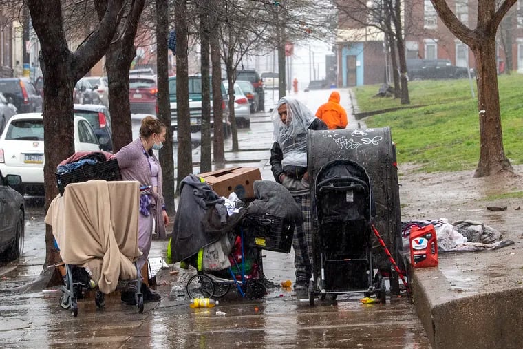 Homeless people gather during a rainy day on April 7 near McPherson Square in Kensington. Instead of involuntary hospitalization, a mental health expert on the city's Board of Health would likely urge the city to offer homeless people an array of services and supports, including recovery housing, shelters, or other environments that support stability and healing, Kate Fox writes.