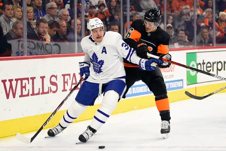 Travis Sanheim (right) fights for position Toronto's Mitch Marner during the first period of Saturday's game.