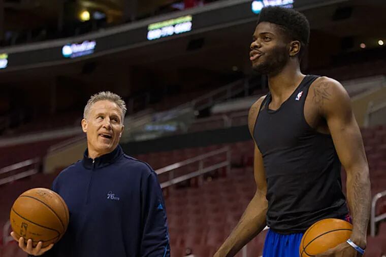 Brett Brown (left) works with Nerlens Noel, right, prior to the first half of an NBA basketball game against the Portland Trail Blazers, Saturday, Dec. 14, 2013, in Philadelphia. (Chris Szagola/AP)