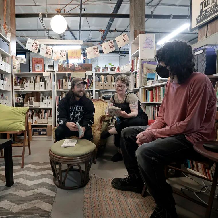 The zine library at the Soapbox, a West Philly community print shop. Studio coordinator Matao Dreskin (from left), board president Karen Lowry, and fellow Belle Handler sit among the zines.