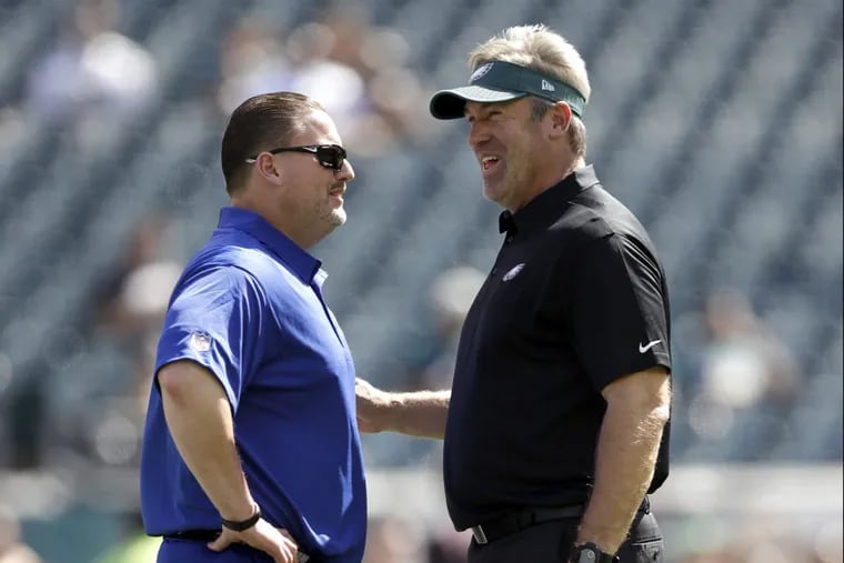 Eagles coach Doug Pederson, right, talks to New York Giants coach Ben McAdoo before the team’s faced off on Sunday.