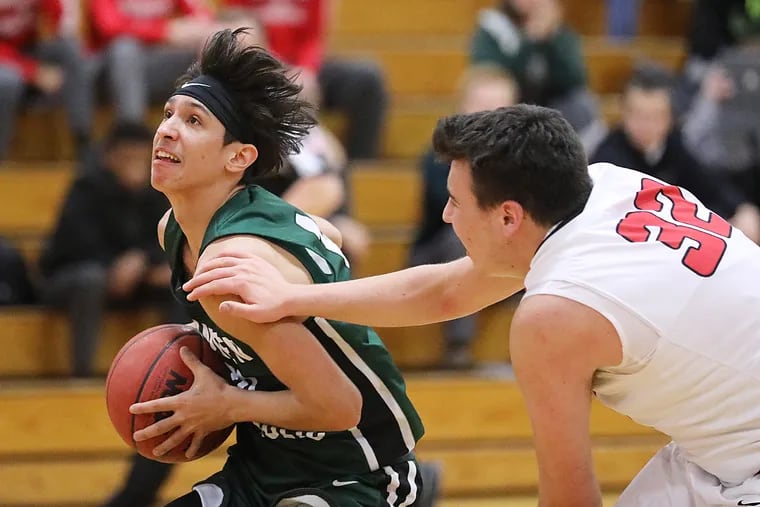 Camden Catholic's Valen Tejada drives to the basket as Cherry Hill east's Sam Serata defends in Tuesday's Olympic Conference game.