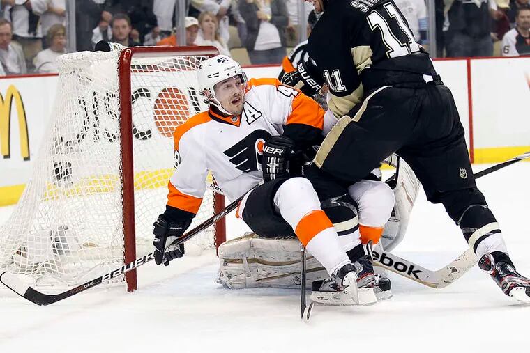 Flyers forward Danny Briere gets sent to ice by the Penguins' Jordan Staal during the third period.