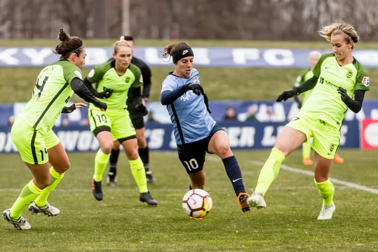 Carli Lloyd dribbles between three Seattle Reign players during her home debut for Sky Blue FC at Rutgers’ Yurcak Field.