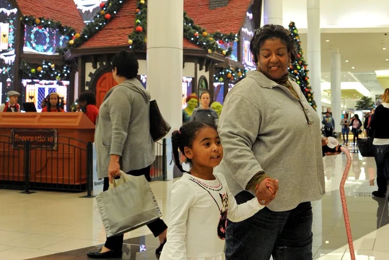 Four year-old Serenity Thompson and her aunt Judy Rogers from Houston, TX leave after seeing Santa Claus at the "Adventure to Santa at Cherry Hill Mall" November 16, 2015.