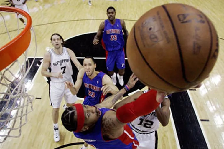 Detroit Pistons guard Allen Iverson, bottom, drives to the basket this week against the Spurs Tonight, the former Sixer takes on his old team in the Motor City. (AP Photo / Eric Gay)