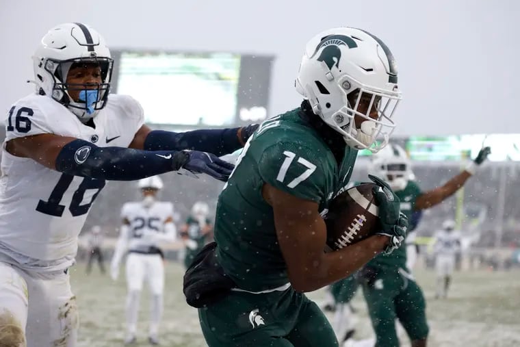 Michigan State's Tre Mosley (17) catches a pass in the end zone for a touchdown against Penn State's Ji'Ayir Brown, left, during the first quarter of an NCAA college football game, Saturday, Nov. 27, 2021, in East Lansing, Mich.