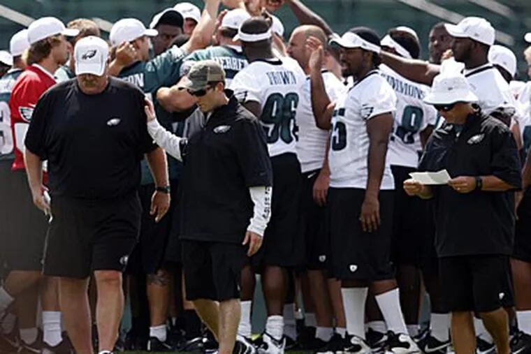Howie Roseman consoles Andy Reid at Eagles training camp on Wednesday. (David Maialetti/Staff Photographer)