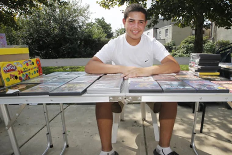 Matthew Marrero, 14, taking care of business at 3rd and Cecil B. Moore. He's selling stuff from around the house to raise money for clothing and supplies he needs for school. (Alejandro A. Alvarez / Staff Photographer)
