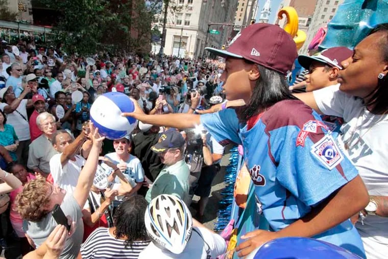 (L-R) Eli Simon, Mo'ne Davis and Zion Spearman signed a beach ball and then handed it to a particular fan at the Kimmel Center during the parade for the Taney Dragons in Phila. on Aug. 27, 2014. ( ELIZABETH ROBERTSON / Staff Photographer )
