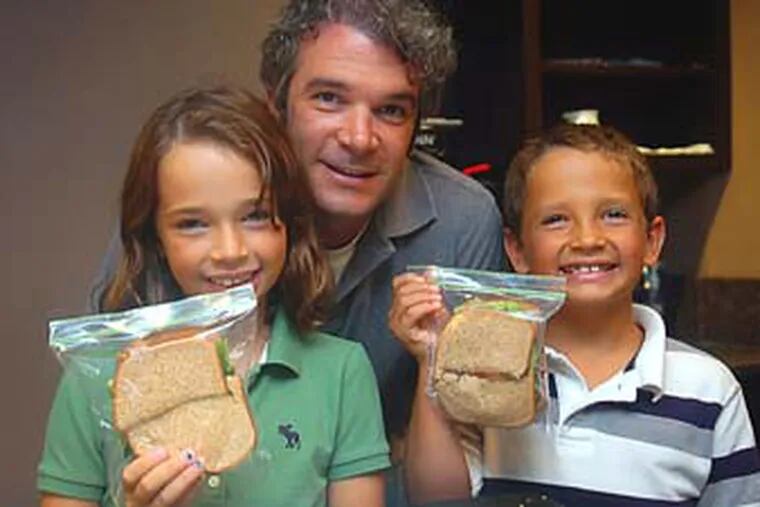 Kali, 10, Drew (dad) and Jacob Masciangelo, 8, pose with their newly made lunch sandwiches. They made cucumber, tomato and lettuce sandwiches on wheat bread; their lunch included lemonade juice boxes and oranges. August 27, 2009  (Sarah J. Glover / Staff Photographer)  EDITOR'S NOTE:  G2FOOD03A    Story on kids helping to make lunches.