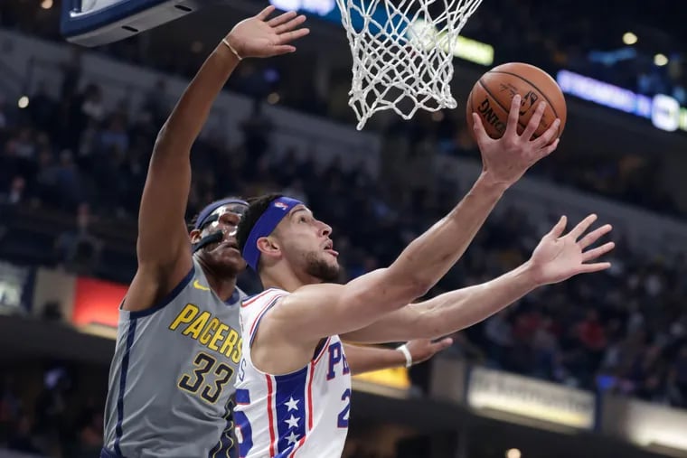 Ben Simmons (25) puts up a layup past Pacers center Myles Turner (33) during the first half.