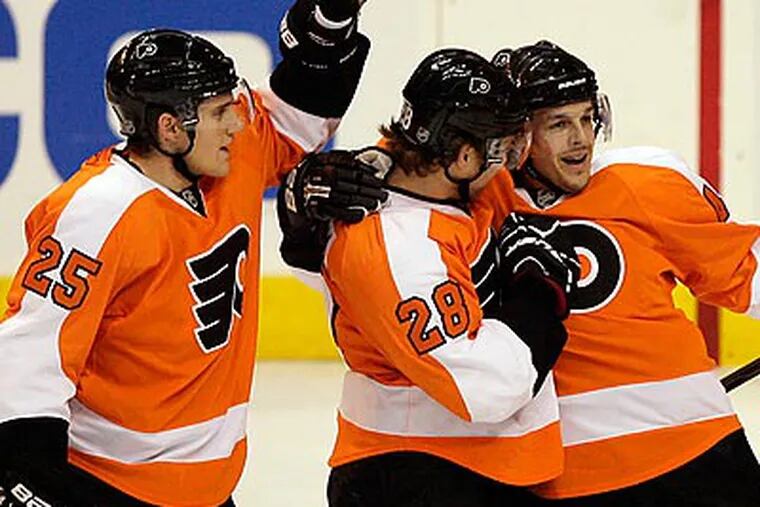 Claude Giroux (center) celebrates with Matt Carle (left) and Danny Briere after scoring a goal during the first period. (Yong Kim/Staff Photographer)