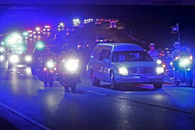 Police escort a hearst carrying the body of Pennsylvania State Trooper David Kedra, Tuesday Sept. 30, 2014, as it traveled from Temple University Hospital to the medical examiners office.  According to authorities Trooper Kedra was fatally wounded Tuesday afternoon during an accidental shooting at a Montgomery County training facility.   (For the Daily News/ Joseph Kaczmarek)