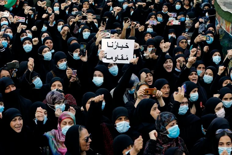 FILE – In this Oct. 15, 2021, mourners chant slogans as they hold a placard with Arabic that reads "Our choice is resistance" during the funeral of three Hezbollah supporters who were killed during clashes, in the southern Beirut suburb of Dahiyeh, Lebanon. Internal company documents from the former Facebook product manager-turned-whistleblower Frances Haugen show that in some of the world's most volatile regions, terrorist content and hate speech proliferate because the company remains short on moderators who speak local languages and understand cultural contexts.
