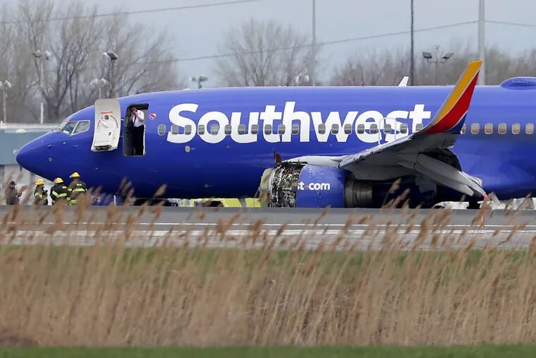 A Southwest Airlines plane with a damaged engine sits on the runway at the Philadelphia International Airport in Philadelphia, PA on April 17, 2018. DAVID MAIALETTI / Staff Photographer