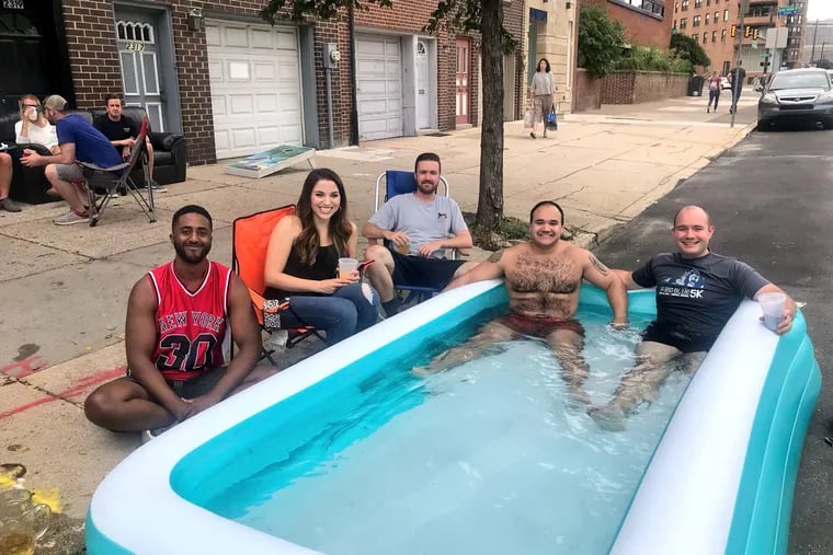 On the 2300 block of Spring Garden, Tyrone Coleman, 25; Elizabeth Chambers, 26; Peyton Wells, 26; Mario Cefalo, 26; and Markus Kampfhammer, 26, enjoy the music from Cefalo's inflatable pool.