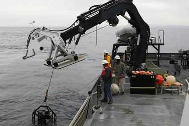 The Eye-in-the-Sea video camera, which weighs 502 pounds, is lowered into the Pacific Ocean off the California coast. (Eric Risberg / AP)