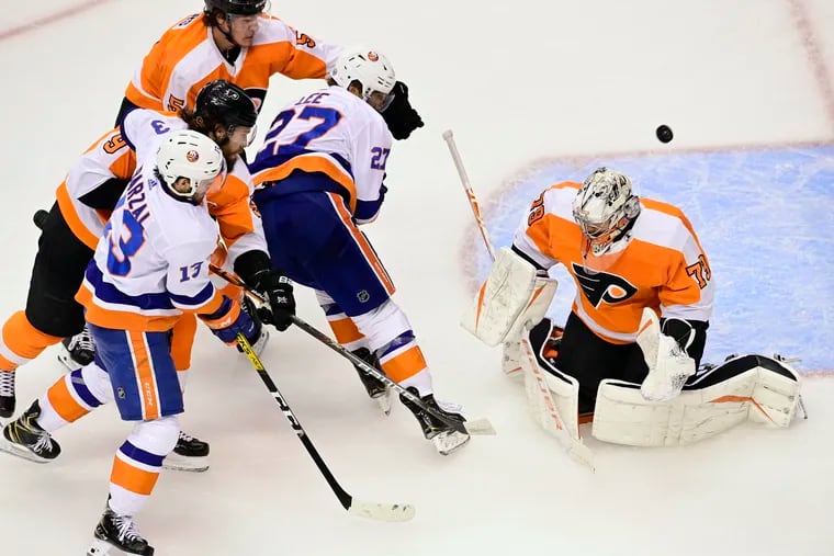 A shot from Islanders defenseman Scott Mayfield (not shown) gets past Flyers goaltender Carter Hart for the game's first goal.