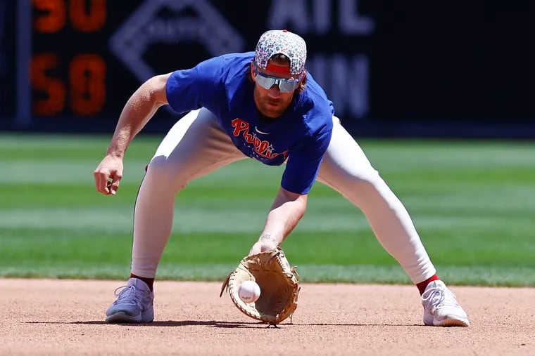 Bryce Harper takes ground balls at first base before a game against the Mets on Sunday.