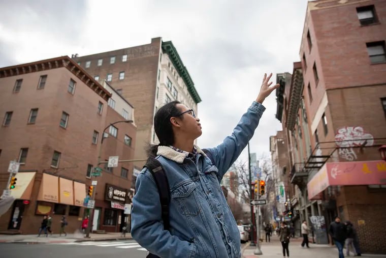 Artist Chenlin Cai points out locations where he would like to paint a mural on 9th and Arch street in Chinatown on Tuesday, Nov. 27, 2018. Cai has painted murals inside Chinese and Japanese restaurants around town.