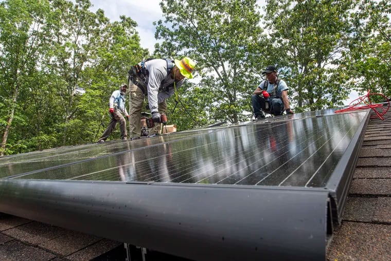 Exact Solar workers (from left) Gabriel Darie, Shane Watson and Enrique Underwood, install solar panels on a home roof in Medford.