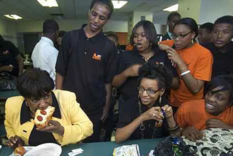 Superintendent Arlene Ackerman takes a bite of cafeteria pizza during a 2008 visit to Overbrook High School. A new policy means principals will be evaluated on the number of students eating breakfast at their schools. (Clem Murray / Staff / File)