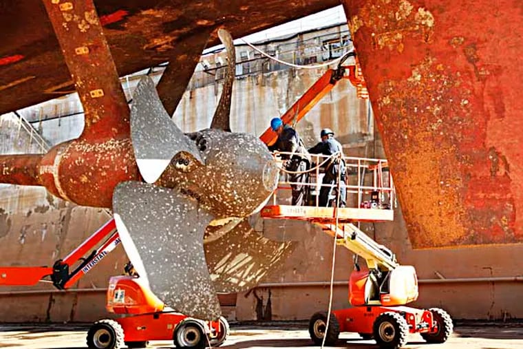 Workers begin to remove the propeller. The Navy is paying Philadelphia Ship Repair to salvage parts from decomissioned frigates. They begin with parts from the decomissioned USS Hawes FFG53 in dry dock at the Philadelphia Navy Yard. November 26, 2013.( MICHAEL S. WIRTZ / Staff Photographer)
